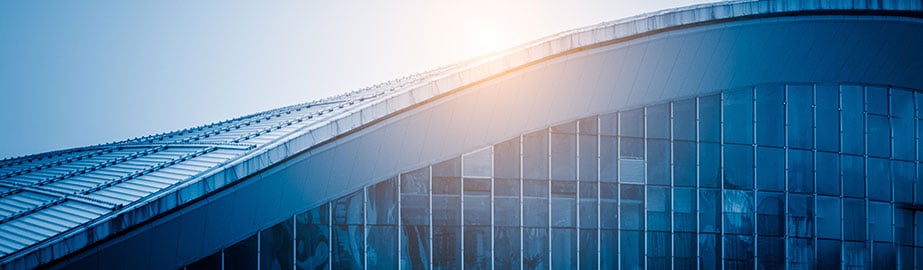 Modern building detail with blue hue and reflection of sun