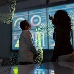 Two women analyzing data on a screen