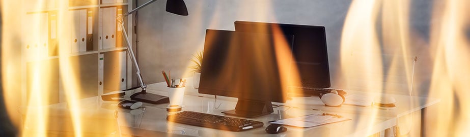 Desk in office surrounded by flames