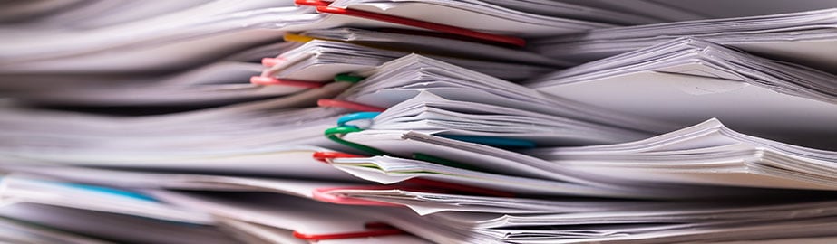 Stack of papers with different colored paperclips