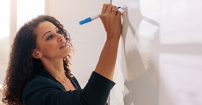 Woman writing on whiteboard