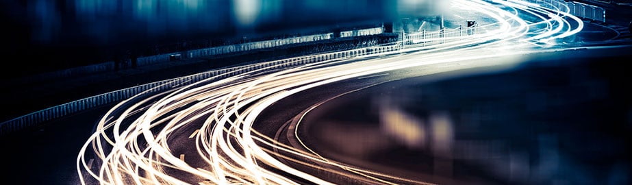 Long exposure image of car lights on curved road